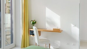 Une pièce comprenant un bureau, une chaise et une fenêtre avec des rideaux.
