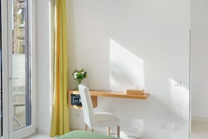A room with a desk, chair, and a window with curtains. - Sorrento Stylish – Double Room with Balcony (Sorrento)
