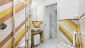 Une salle de bain moderne avec une douche à parois de verre, un lavabo blanc et une baignoire.