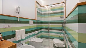 Kylpyhuoneessa on suihku, wc, bidee ja seinälle asennettu hiustenkuivaaja.
