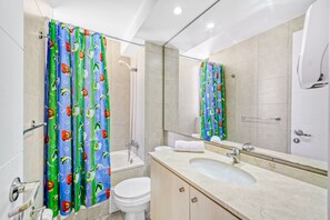 Une salle de bain équipée d’une douche, de toilettes, d’un lavabo et d’un miroir.