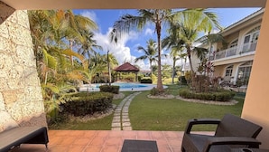 Un'area patio con piscina, palme e un gazebo.