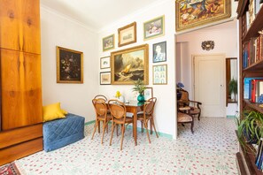 A room with a dining table, chairs, a blue sofa, and a wooden wardrobe. - Apartment 'Casa Beatrice' with Mountain View, Wi-Fi and Air Conditioning (Sorrento)