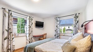A bedroom with a bed, a desk, and a TV mounted on the wall. - Apartment 'Beim Häusler' with Wi-Fi (Radibor)