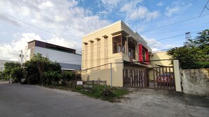 A two-story building with a beige facade and a red accent on the upper level. - Cozy Studio Near Clark International Airport, Philippines (Mabalacat City)