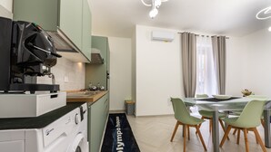 Eine moderne Küche mit Waschmaschine, ein Essbereich mit Tisch und Stühlen sowie ein Flur mit Teppich.