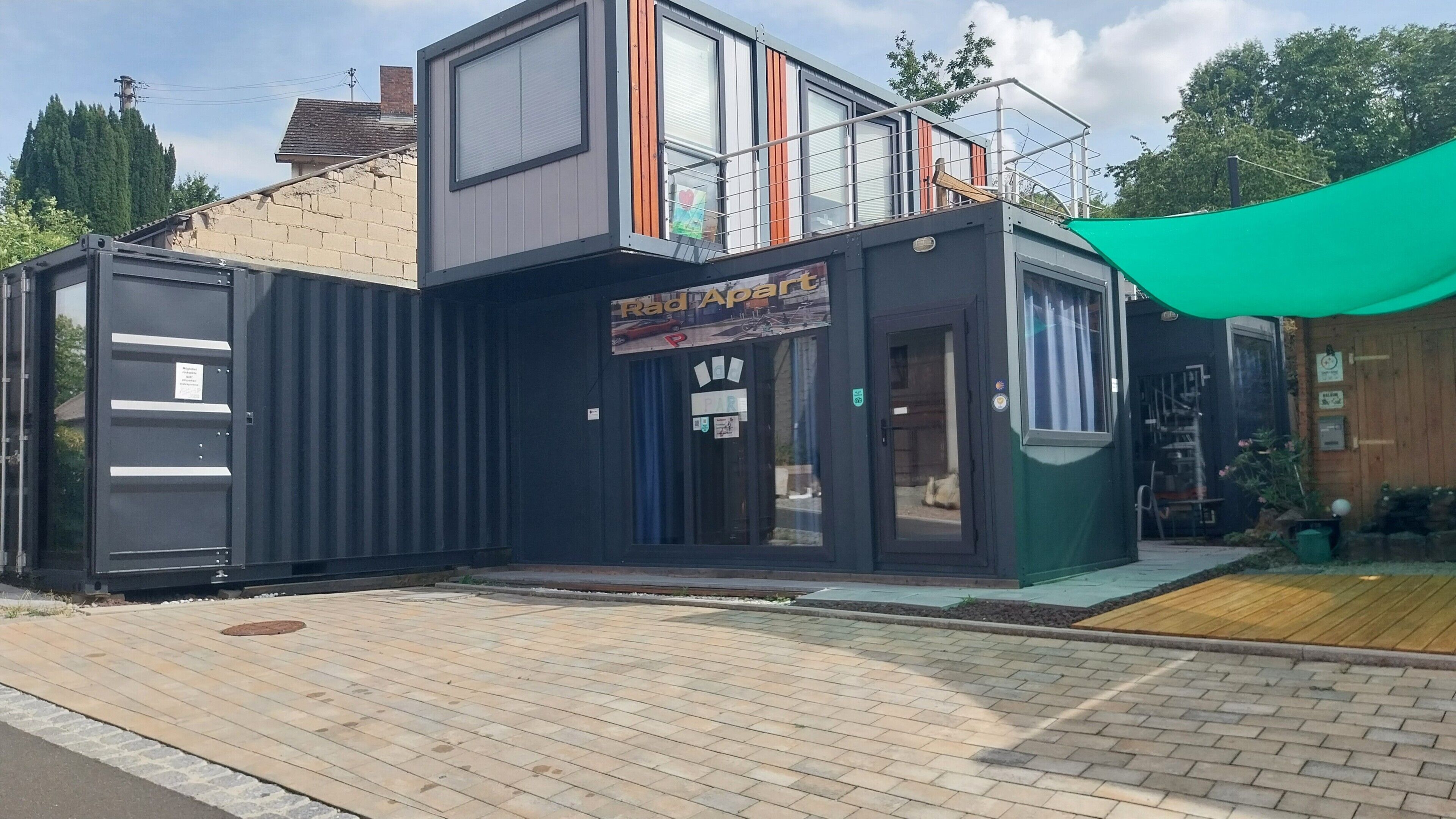 Un edificio moderno con techo plano, entrada cubierta y un letrero que dice 'Rad Art'.
