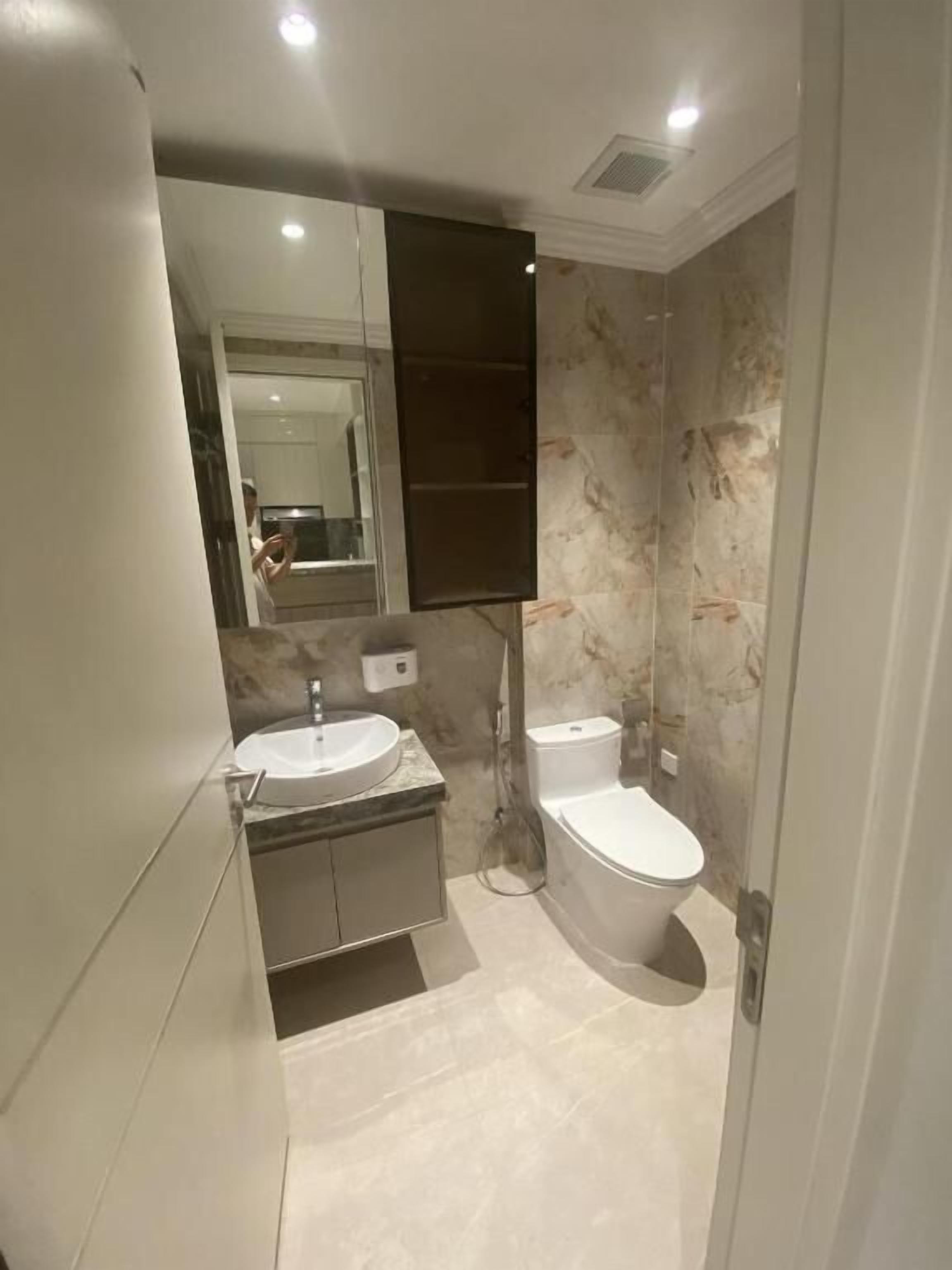 Ein modernes Badezimmer mit Waschbecken, Toilette und einem großen Spiegel.