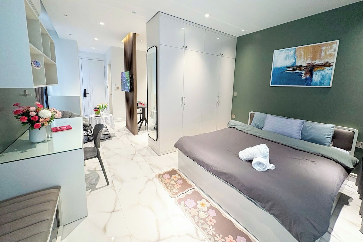 Une chambre à coucher moderne avec un grand lit, un bureau et une armoire.