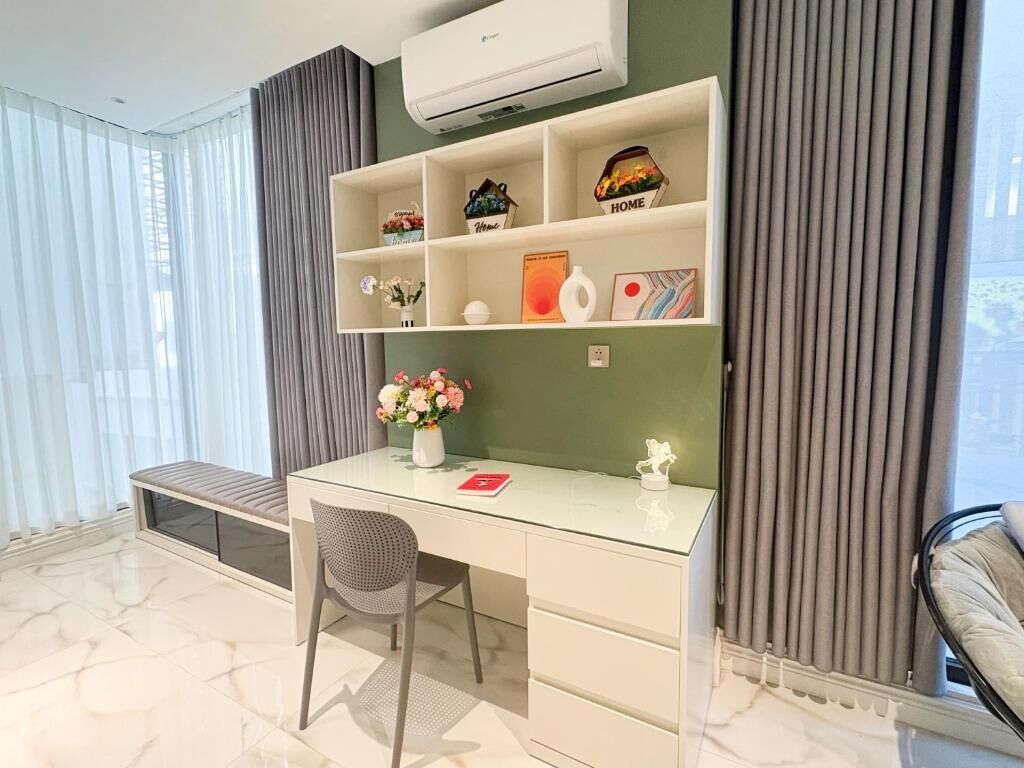 Ein modernes Zimmer mit einem Glastisch, einem Sessel, einer Bank und einem Regal mit Dekoration.
