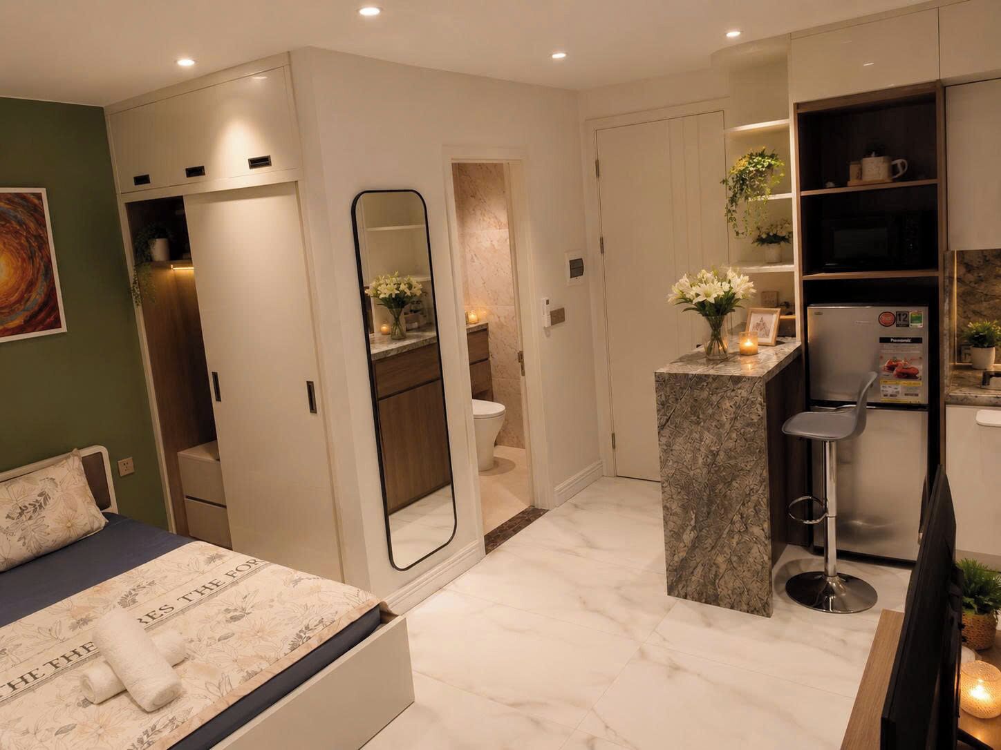 A modern bedroom with a bed, a bathroom, and a kitchenette.