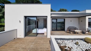 A modern house with a bedroom, a balcony with seating, and a view of the landscape. - A beautiful luxury villa in a quiet location 1 km from the beach and town centre (Cavalaire-sur-Mer)