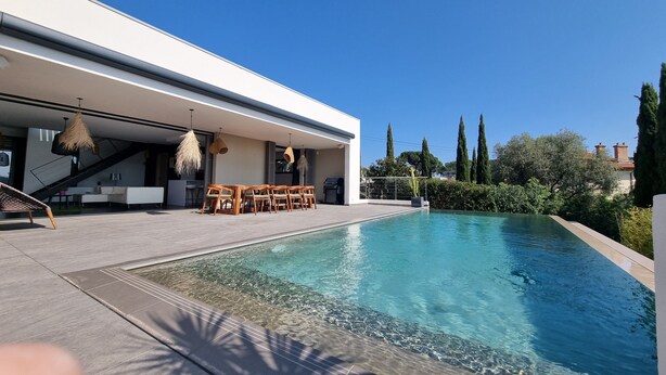 A modern outdoor pool area with a dining set and a covered seating area. - A beautiful luxury villa in a quiet location 1 km from the beach and town centre (Cavalaire-sur-Mer)