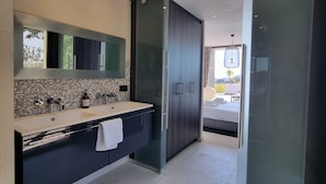 A modern bathroom with a large mirror, a sink, and a shower area. - A beautiful luxury villa in a quiet location 1 km from the beach and town centre (Cavalaire-sur-Mer)
