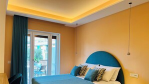 Ein modernes Schlafzimmer mit einem Bett, Nachttischen und Blick durch eine Glastür.