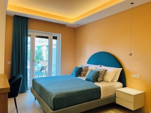 Un dormitorio moderno con una cama, mesitas de noche y vistas a través de un ventanal.