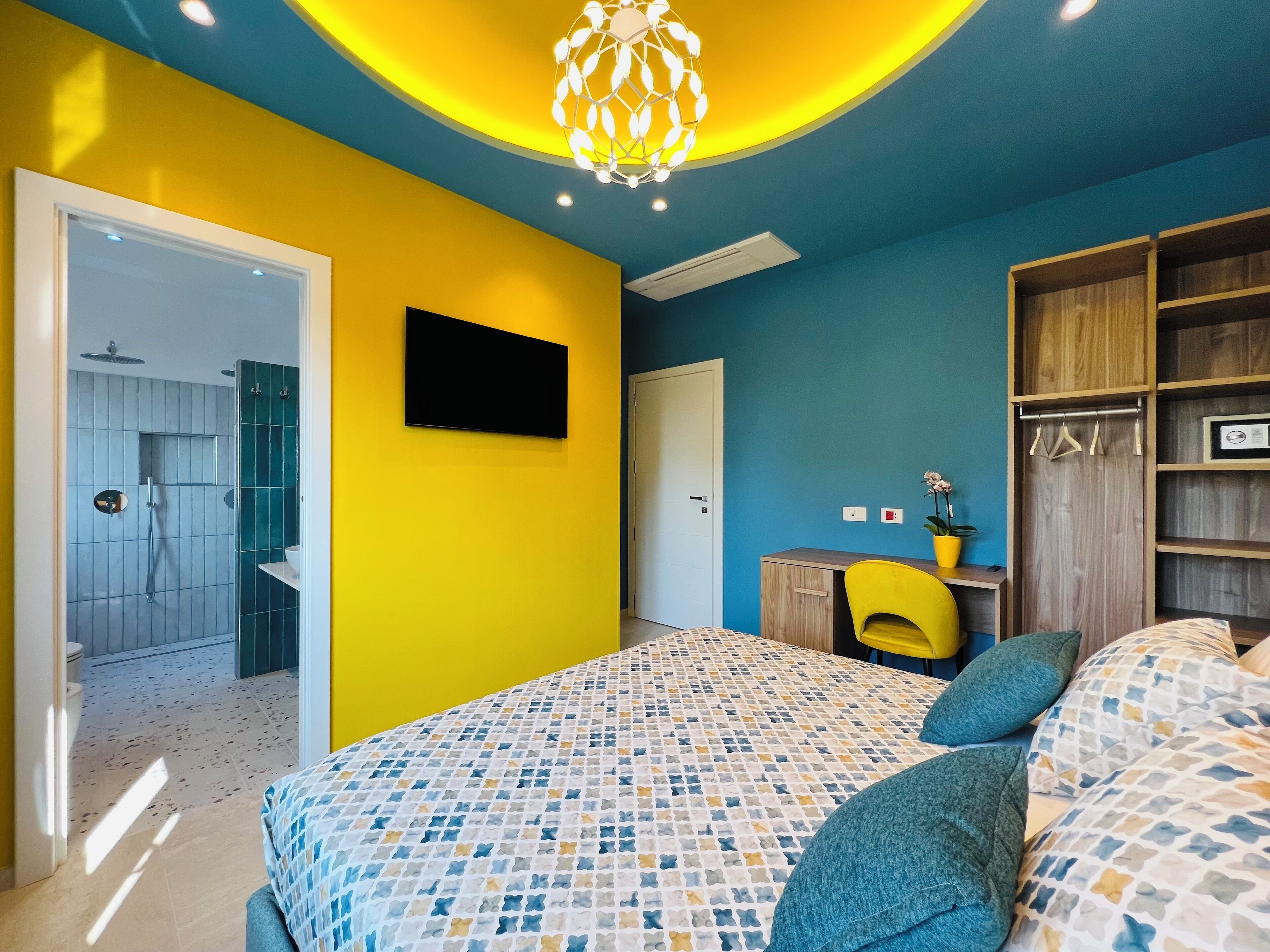 A bedroom with a bed, a desk, a chair, and a wardrobe.