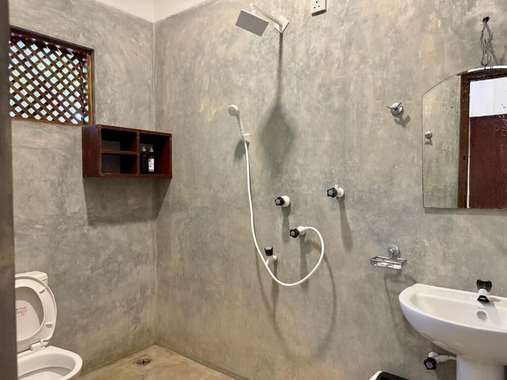A bathroom with a shower, toilet, and sink.
