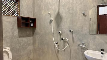A bathroom with a shower, toilet, and sink.