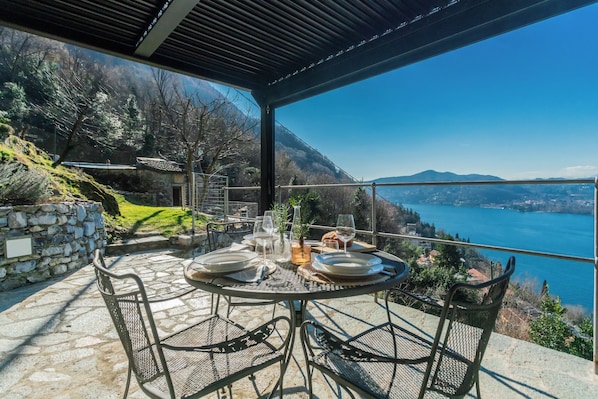 A table set for two with a view of a lake and mountains.