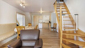 Een modern interieur met een eethoek, keuken en een houten trap.