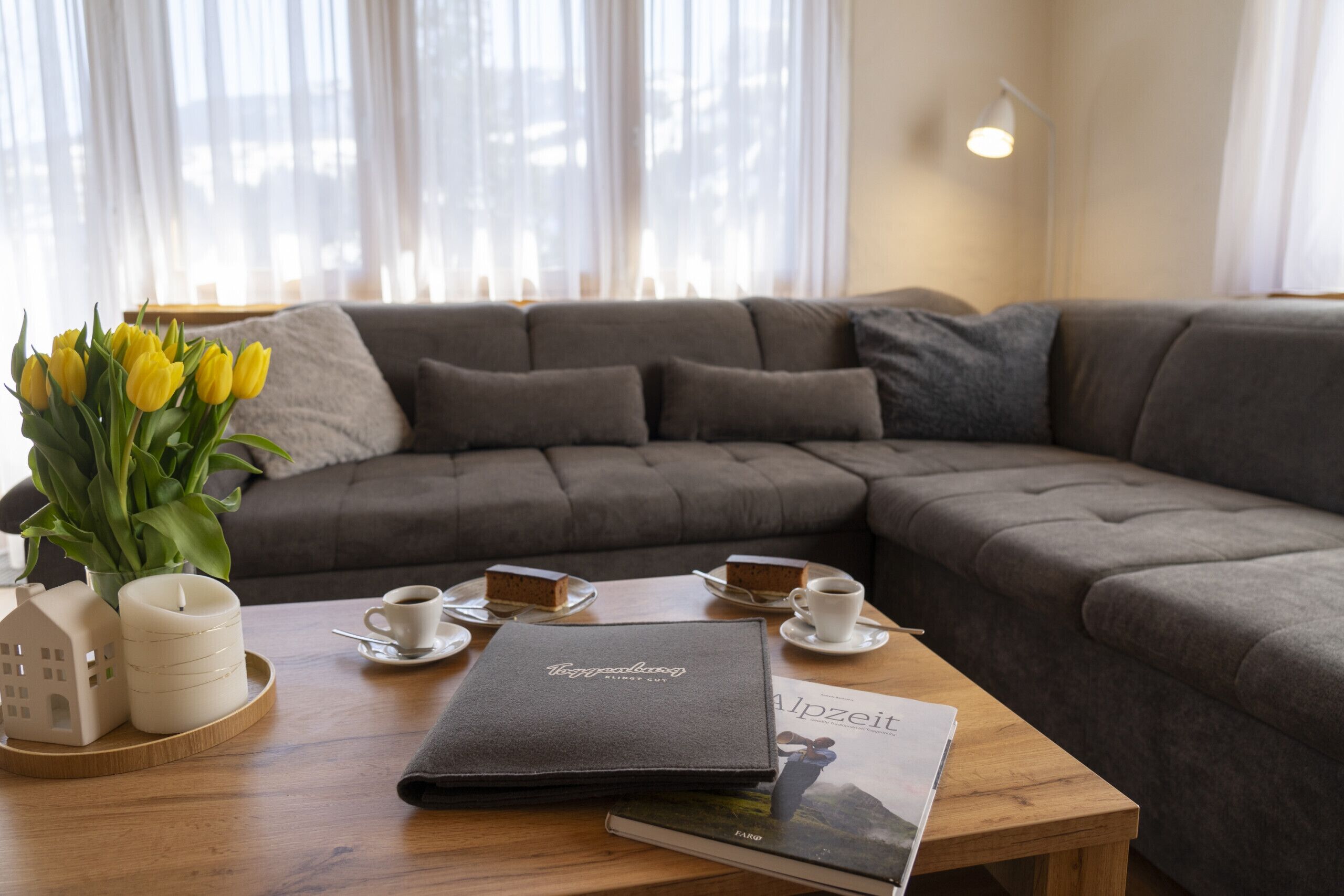 Gemütliches Wohnzimmer mit Sofa, Couchtisch und Tulpen