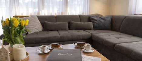 Gemütliches Wohnzimmer mit Sofa, Couchtisch und Tulpen