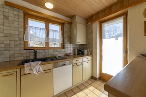 Bright kitchen with sink, dishwasher and garden access - Chalet Stadel – Holiday Home with Fireplace (Unterwasser)