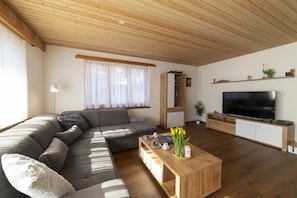 Helles Wohnzimmer mit grossem Sofa und TV