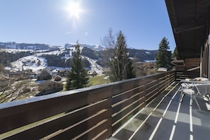 Sonniger Balkon mit Panoramablick auf die verschneiten Berge
