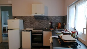 Une cuisine compacte équipée d’un réfrigérateur, d’un four et d’un petit plan de travail.
