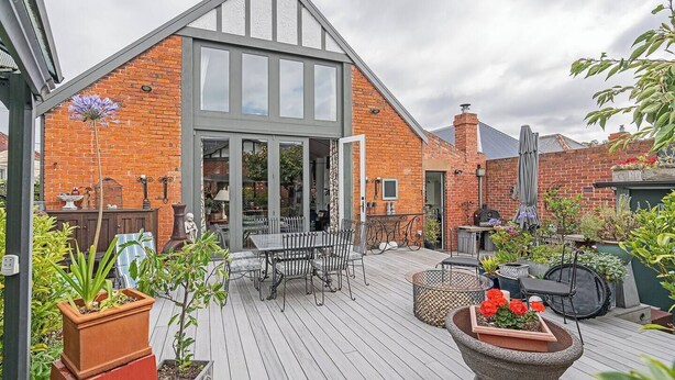 A modern house with a large deck, outdoor seating, and a brick facade. - The Church House Spacious Heritage Escape for Two (North Hobart)