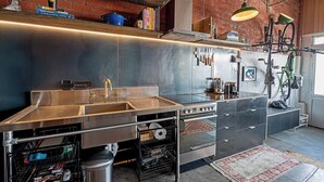 Une cuisine moderne dotée d’appareils électroménagers en acier inoxydable, d’un grand évier et d’un vélo fixé au mur.