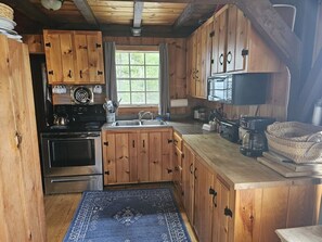 Une cuisine rustique avec des meubles en bois, un poêle et un évier.