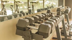 A row of dumbbells in a gym with large windows and a view of greenery outside. - *Modern apartment* near Antigua Guatemala (Santo Tomas Milpas Altas)