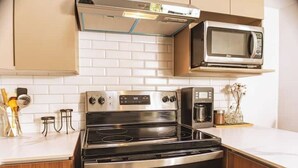 A kitchen with a stainless steel stove, a microwave, and a coffee maker. - *Modern apartment* near Antigua Guatemala (Santo Tomas Milpas Altas)