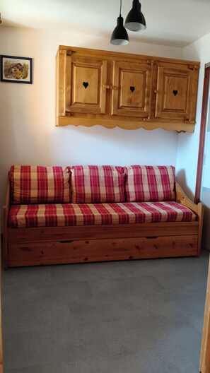 A wooden bench with a plaid cushion, a wooden cabinet with heart-shaped cutouts, and a pendant light. - Comfortable 6-person apartment Saint Jean d'Arves les Sybelles 3* rated (Saint-Jean-d'Arves)