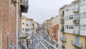 A narrow street with buildings on either side, balconies, and a clear sky. - GuestHost - A bright and welcoming 50 square meters apartment, perfect for four people, located on the third floor of a building without an elevator.The property is located in a very quiet area and is close to San Giovanni Bosco Hospital. Thanks to publi (Turin)