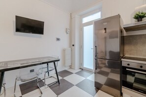 A kitchen with a stainless steel refrigerator, a built-in oven, and a checkered floor. - GuestHost - A bright and welcoming 50 square meters apartment, perfect for four people, located on the third floor of a building without an elevator.The property is located in a very quiet area and is close to San Giovanni Bosco Hospital. Thanks to publi (Turin)