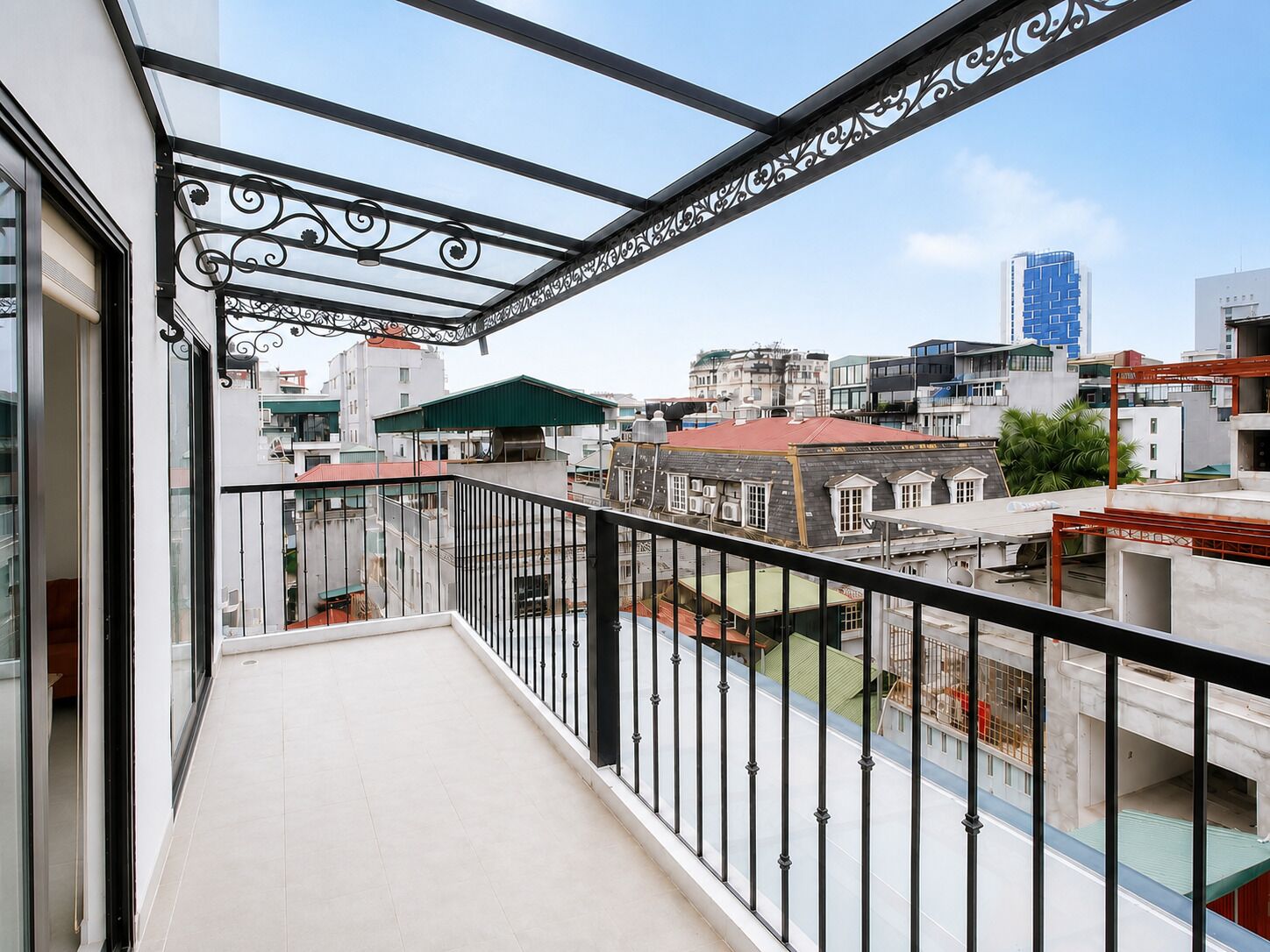 A balcony with a metal railing and a view of surrounding buildings.