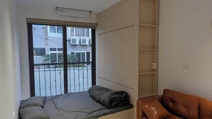 A modern living room with a sofa, a coffee table, and a built-in bench with storage. - ERA Trung Liet SIGNATURE (Hanoi)