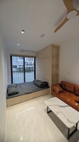 Uma sala de estar moderna com um sofá, uma mesa de centro e um banco embutido com espaço para guardar.