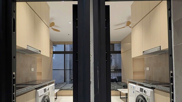 A modern apartment with a kitchen, a washer, and a dining area. - ERA Trung Liet SIGNATURE (Hanoi)