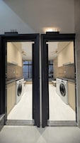 Um apartamento moderno com cozinha, máquina de lavar e área de jantar.