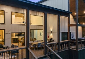 Ein modernes Haus mit Terrasse, großen Fenstern und einem Essbereich.