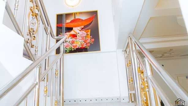 A staircase with a framed floral artwork on the wall. - Elu Hotel Diamant (Douala)