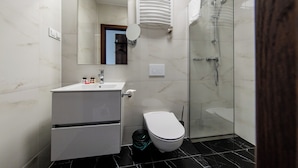 A modern bathroom with a white vanity, a toilet, a glass shower enclosure, and a mirror. - Sleep&Fly Okecie (Warsaw)