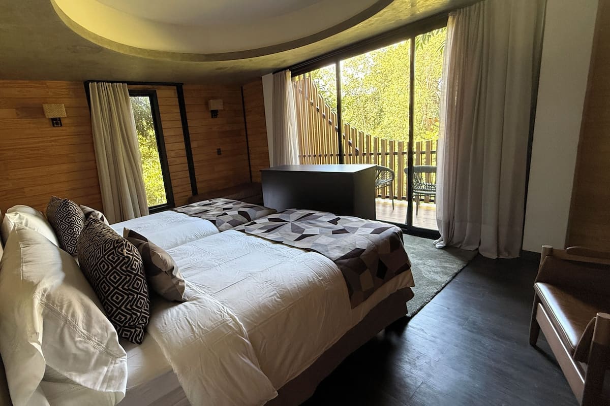 Un dormitorio con una cama grande, un escritorio y vistas al exterior.