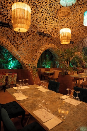 A restaurant with a unique woven ceiling, tables set with wine glasses, and a warm ambient lighting. - Entre Arboles Iguazu, Singular Collection by Amerian (Puerto Iguazú)