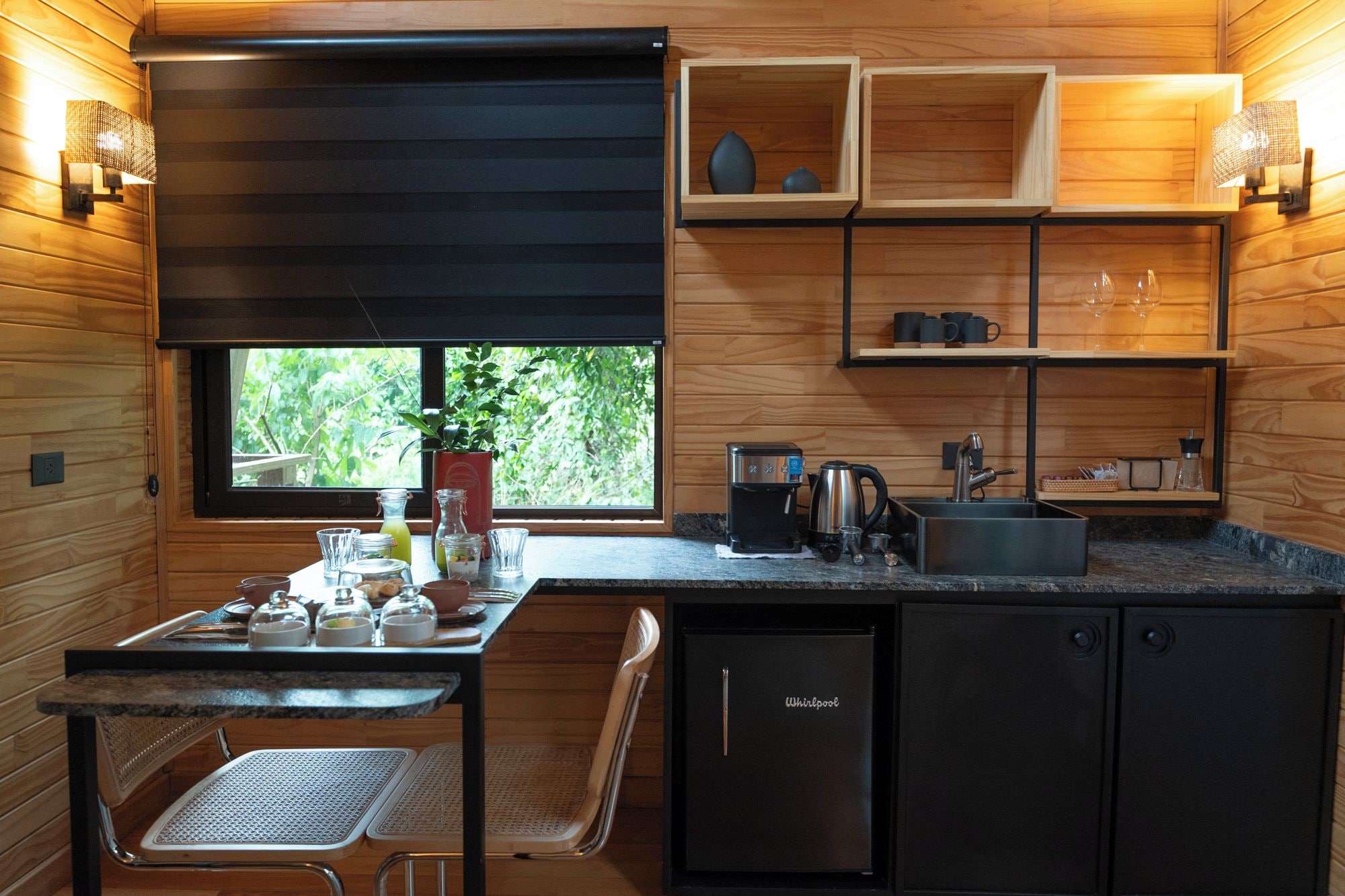 Una cocina compacta con ventana, un lavamanos, una cafetera y un tostador.